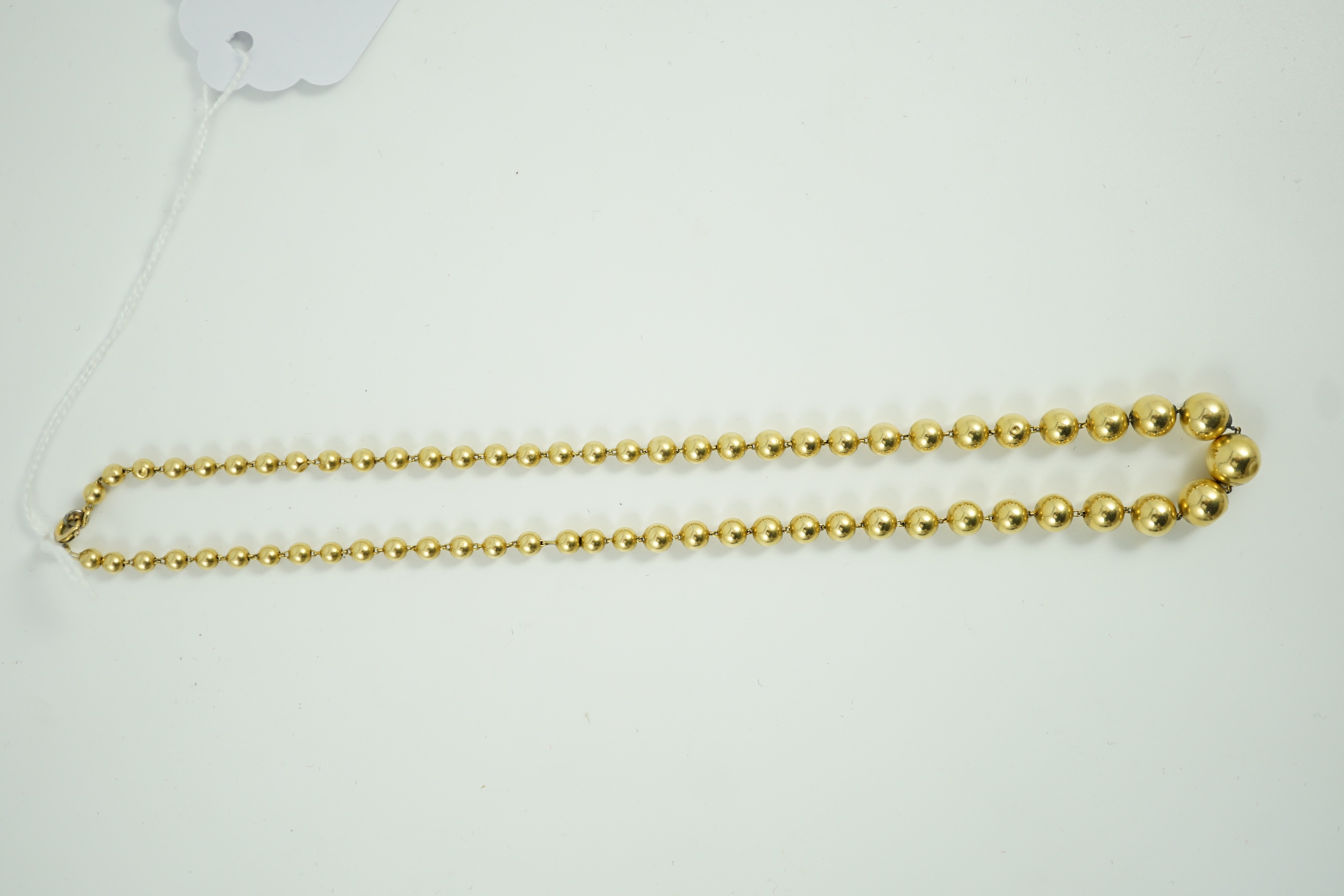 A French? graduated yellow metal bead necklace, 42cm, gross 21.4 grams.
